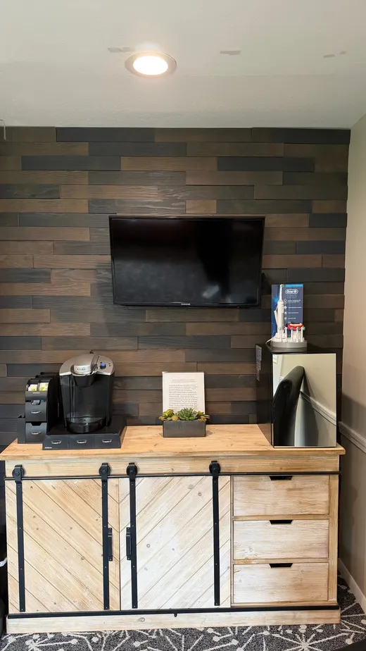 The refreshment bar with a Keurig on a farmhouse cabinet against a wood plank wall