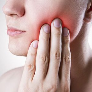Woman holding her jaw in pain