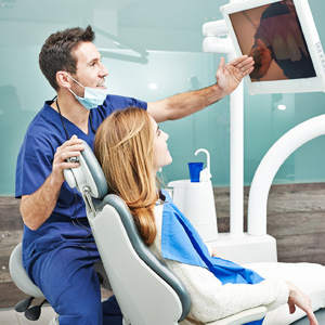 Dentist with patient reviewing charts and scans